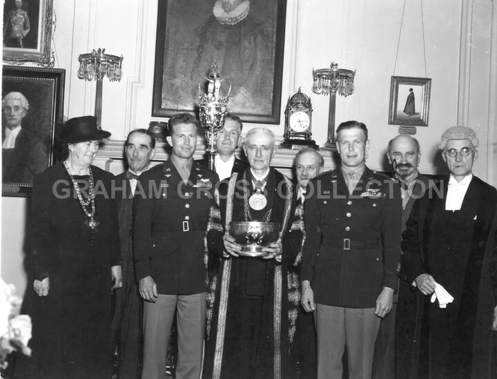 The 353rd and 55th Fighter Groups presented a 46-ounce silver rose bowl dating from 1735 to the town of Colchester as a token of friendship June 30, 1945. Left to right are the Mayoress, Alderman S. Bloomfield, Col. Glenn E. Duncan, the Town Sergeant, the Mayor, P. A. Sanders, Lt Col. Jack W. Hayes, Mr H. W. Poulter and the Town Clerk.