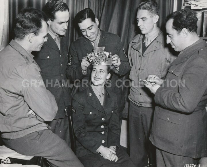 Corporal Newell is crowned ‘Queen of the WACS.’ Left to right are Sgt. Gordon Kirby, Sgt. Peter Lisagor, Sgt. Leonard Celestino, Sgt. Robert Wood and Sgt. Tony Cordano.