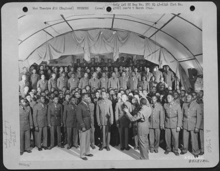 Some of the Chorus members at Eye on September 1, 1943. They are under the direction of Sergeant Jordan from St. Paul Minnesota and listening is Chaplain Perkins. (USAF)