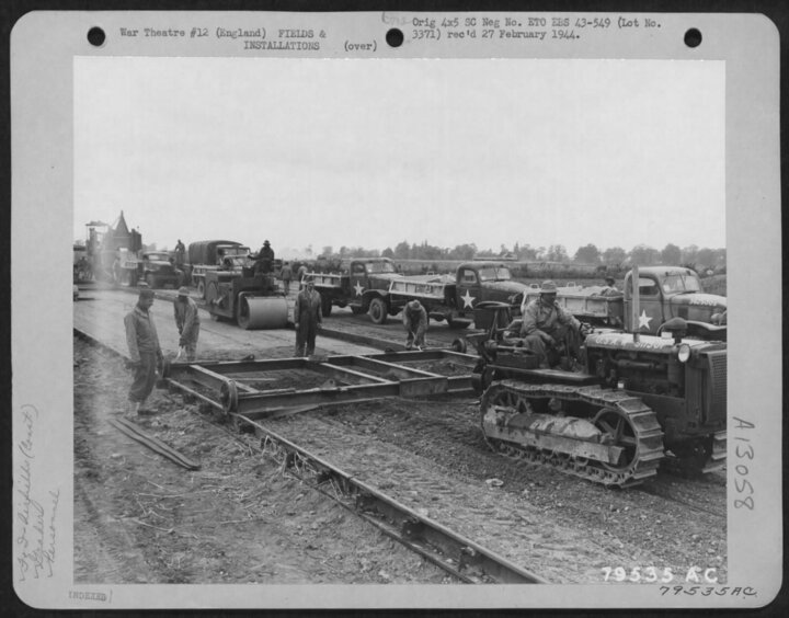 Men from the 923rd operate a new surface grader, invented by M/Sgt. Martin (standing behind the grader), at Eye June 1, 1943 (USAF)