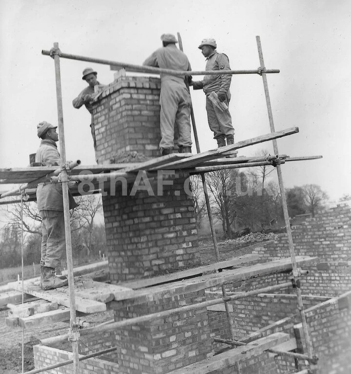 Bricklayers from the 859th Engineers build a chimney at Eye. (Hallock Collection)