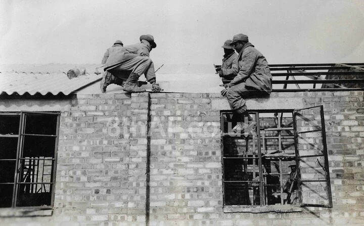 Men fix a roof on the crew drying room building at Debach. (Hallock Collection)